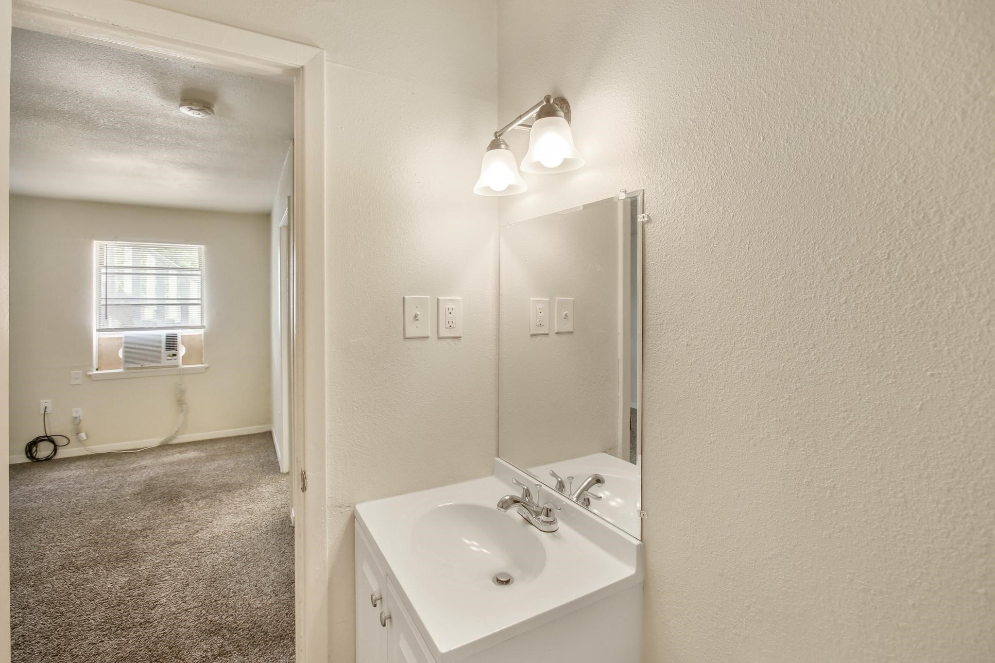 5415 3 Rd Street, Unit 1 Danbury, TX 77534 - Photo 6 of 8 a bathroom with a sink a mirror and a shower