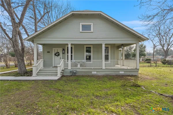 a view of a house with a yard patio and fire pit