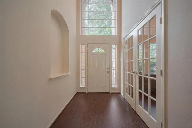 a view of a hallway with wooden floor and entryway