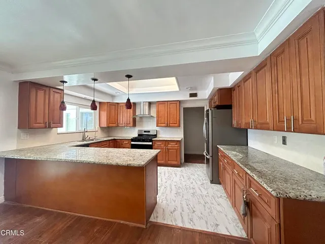 a kitchen with stainless steel appliances granite countertop a sink stove and refrigerator