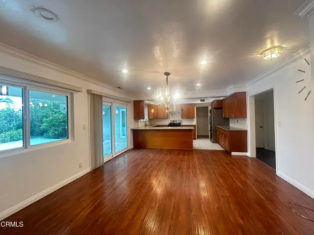a view of kitchen with kitchen island wooden floor center island and stainless steel appliances