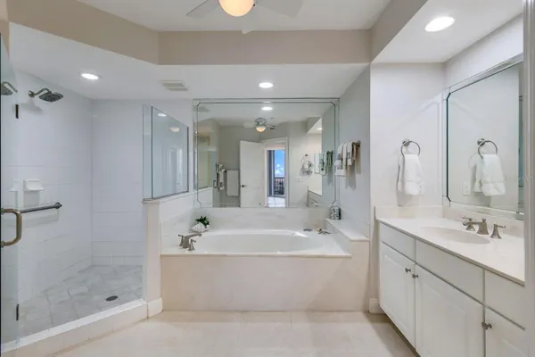 a bathroom with a bathtub shower sink and mirror