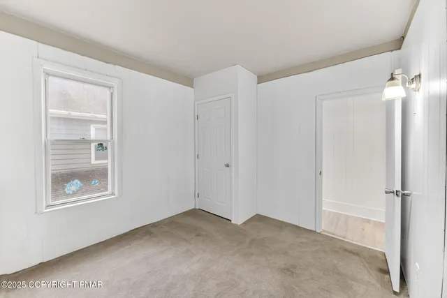an empty room with windows and closet