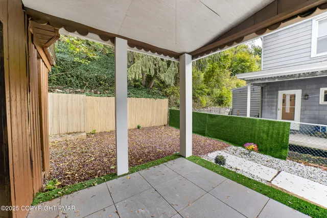 a view of backyard with large trees and plants