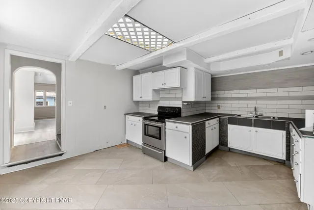 a kitchen with granite countertop white cabinets and stainless steel appliances
