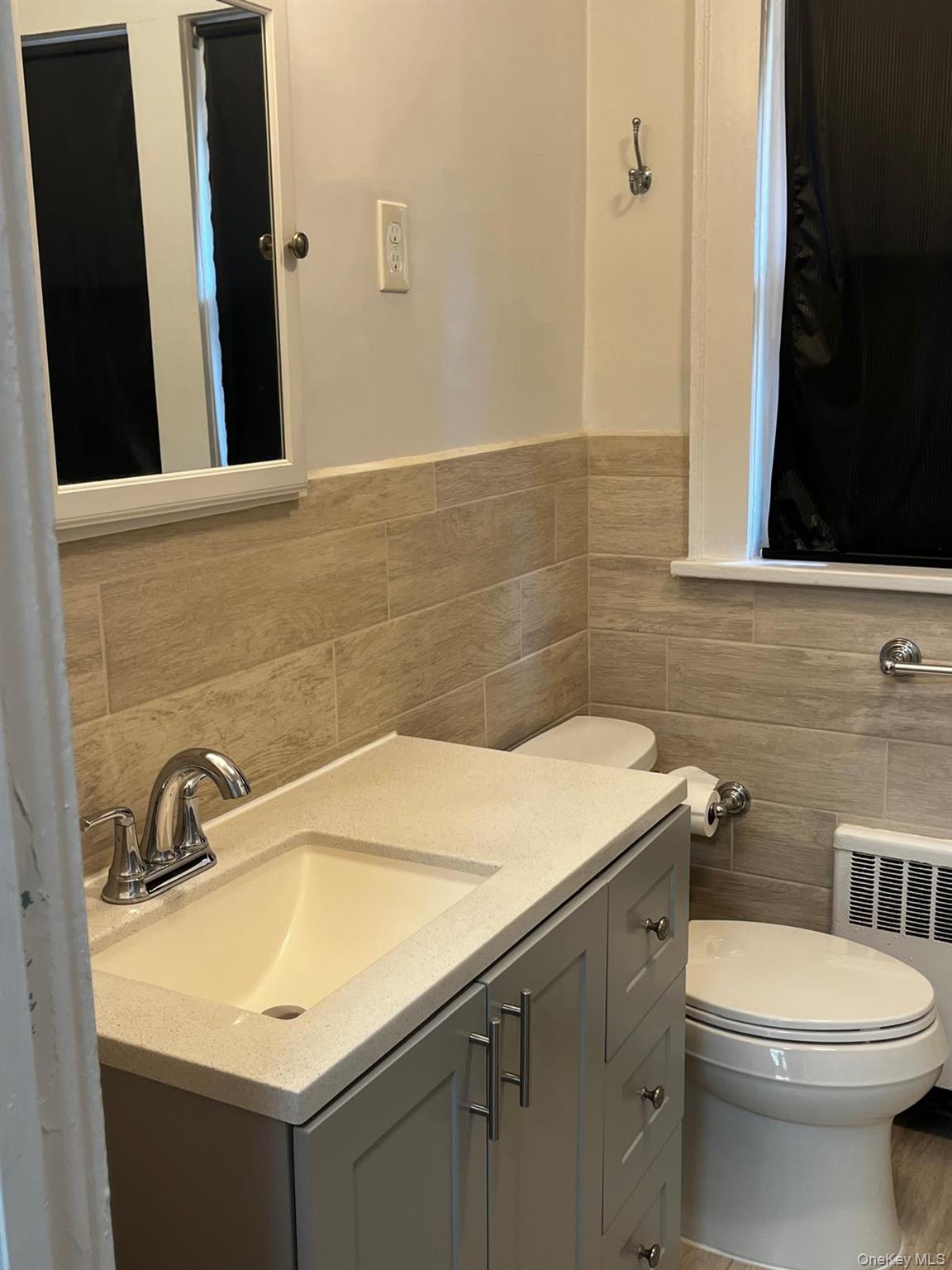 440 Mile Square Road Yonkers, NY 10701 - Photo 21 of 29 Bathroom featuring a gray vanity with integrated sink, chrome faucet, and coordinating cabinet hardware