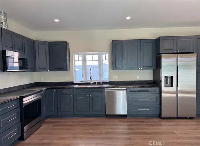 a kitchen with granite countertop a refrigerator and a sink