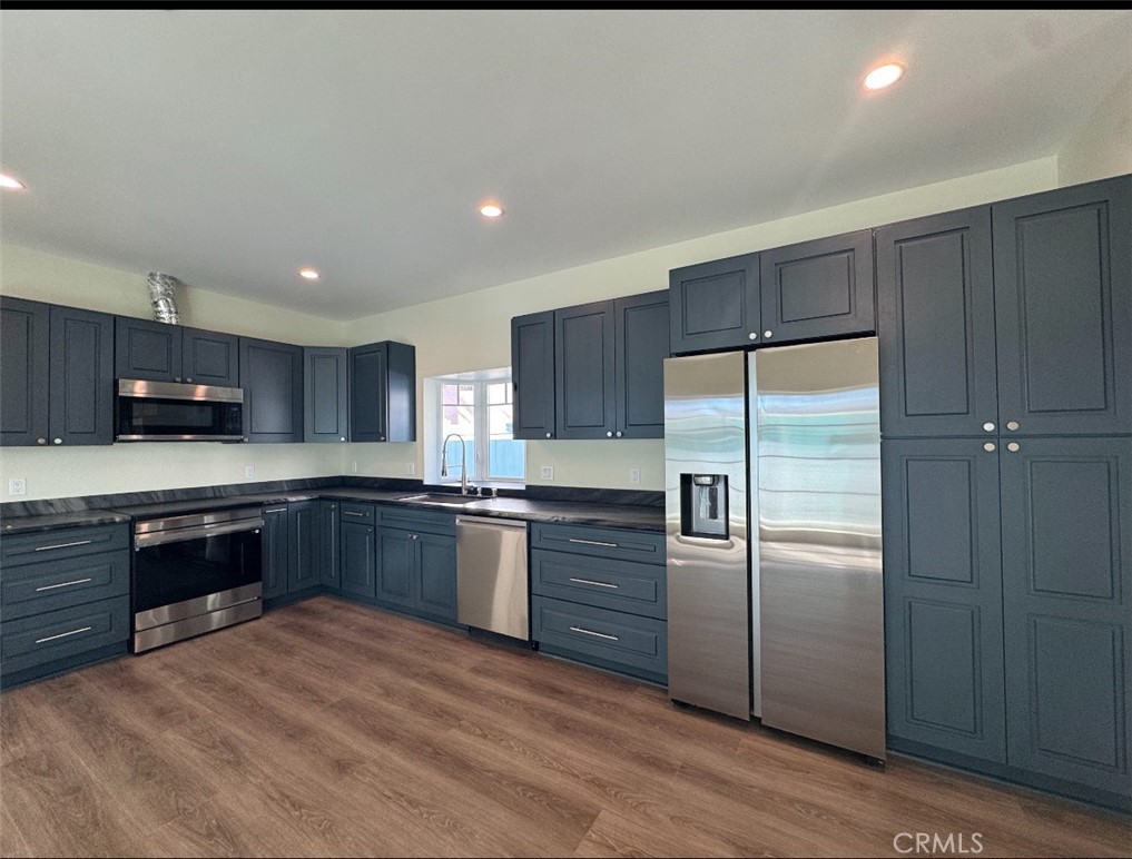 1319 Amapola Avenue Torrance, CA 90501 - Photo 14 of 17 a large kitchen with stainless steel appliances granite countertop a refrigerator a sink dishwasher a stove with wooden cabinets and floor