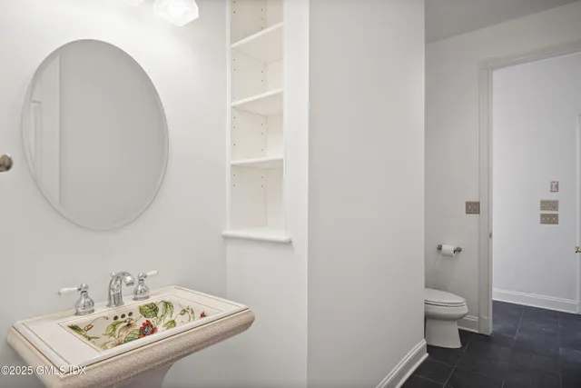 a bathroom with a sink a toilet and a mirror