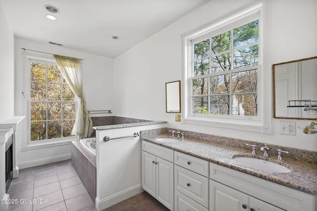 a kitchen with granite countertop white cabinets and a window