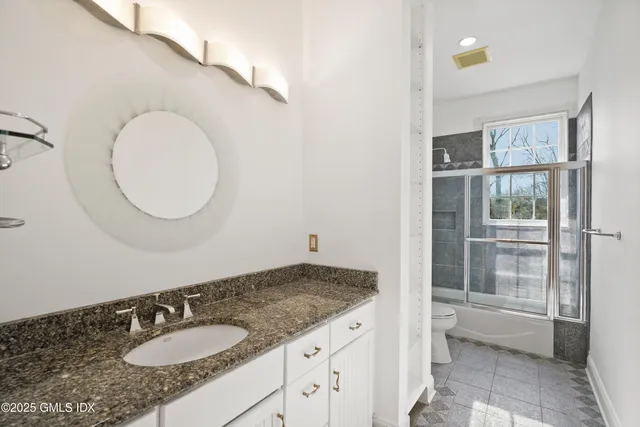 a bathroom with a granite countertop sink and a mirror