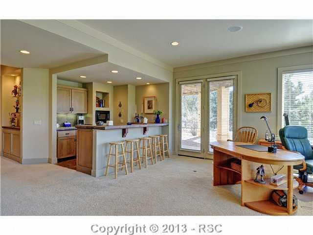 4265 Hidden Rock Road Colorado Springs, CO 80908 - Photo 20 of 25 Walk-out Basement w/ 9’ Ceilings Features Family Room w/ Stone Fireplace and Wet Bar w/ Refrigerator, Dishwasher & Microwave