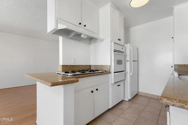 a kitchen with stainless steel appliances granite countertop a refrigerator and a stove