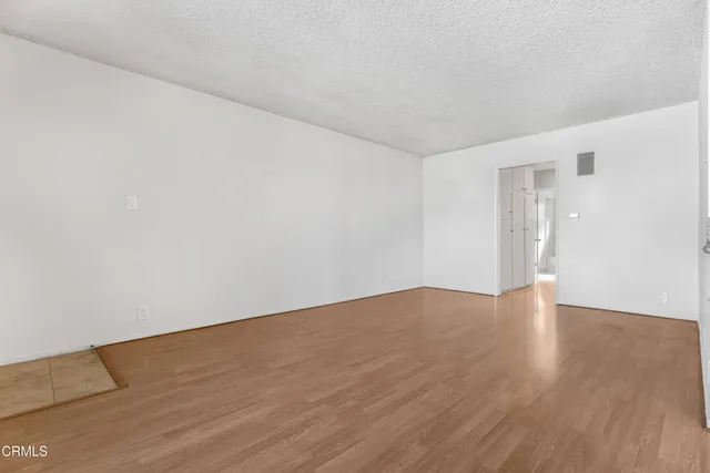 a view of an empty room with wooden floor