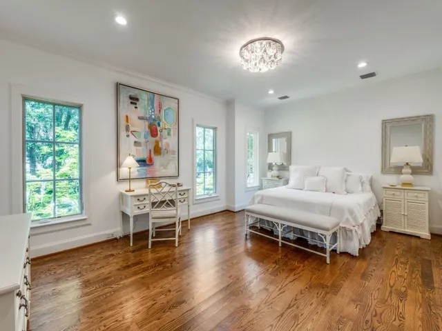 a bedroom with a bed and a table in it with window