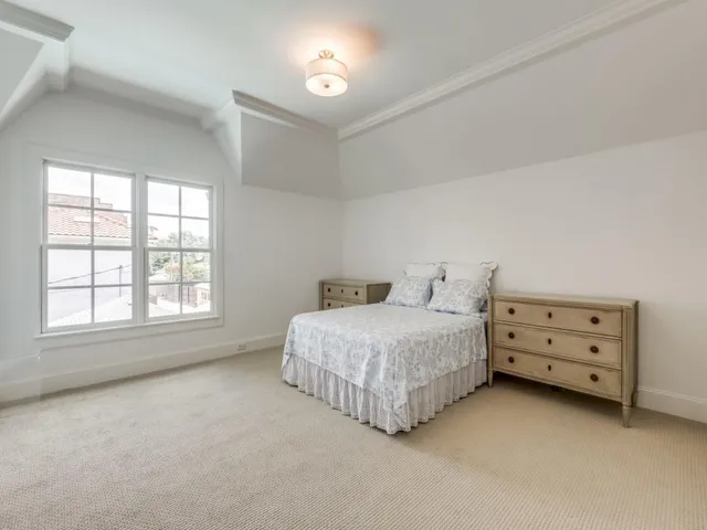 a spacious bedroom with a bed and a window
