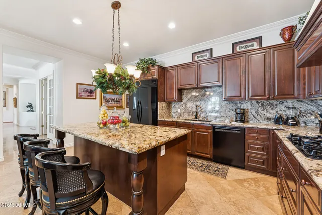 a kitchen with kitchen island a dining table chairs stainless steel appliances and cabinets