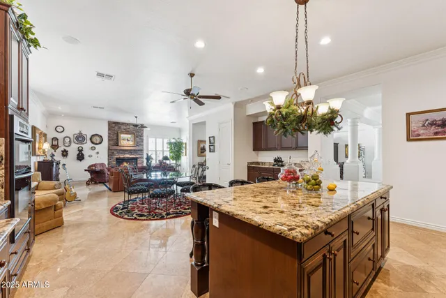 a kitchen with stainless steel appliances granite countertop a table chairs and a refrigerator