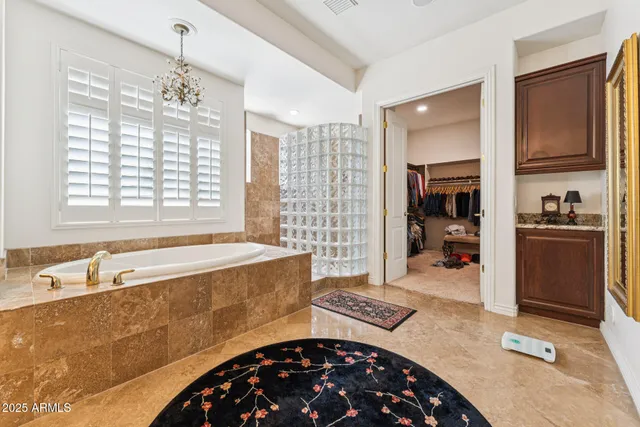 a spacious bathroom with a tub sink and mirror