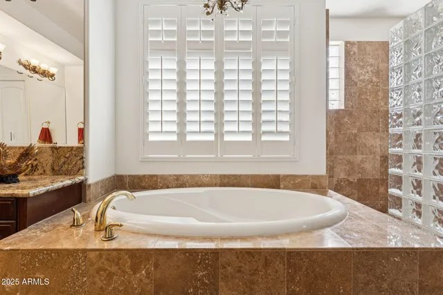 a spacious bathroom with a tub sink and mirror