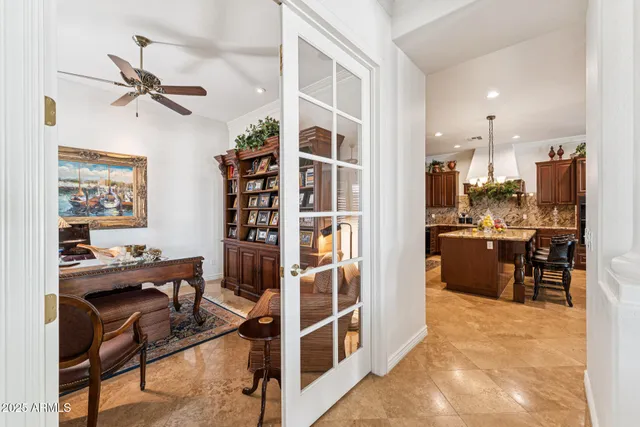 a view of a dining room with furniture a chandelier and large windows