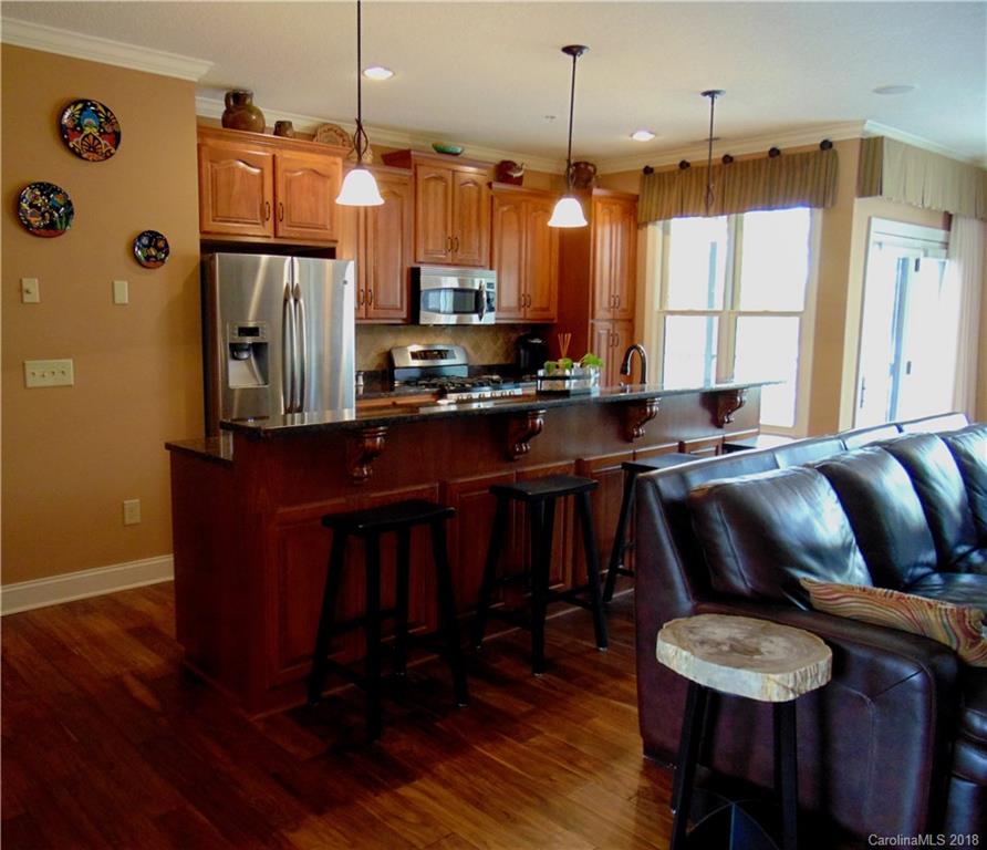 2010 Marina Pointe Road, Unit 2010 Salisbury, NC 28146 - Photo 6 of 28 a kitchen with stainless steel appliances kitchen island granite countertop a table chairs and a refrigerator
