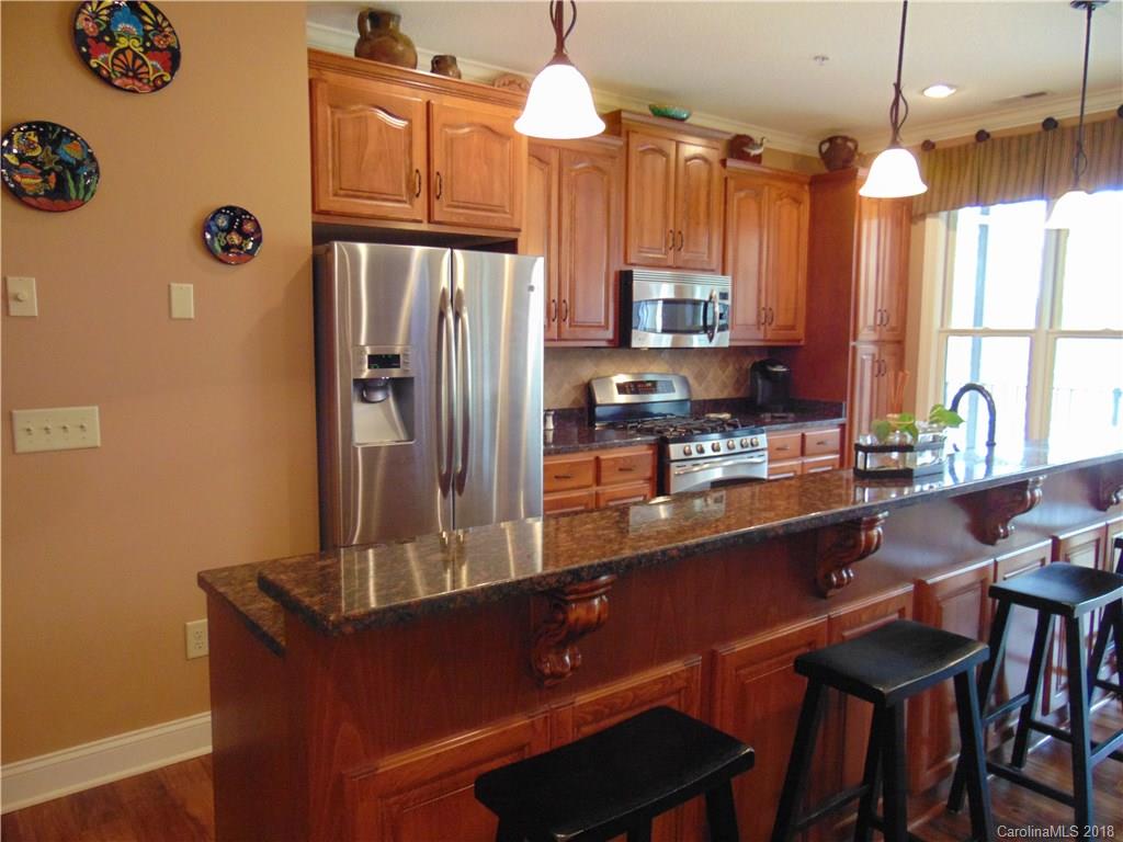 2010 Marina Pointe Road, Unit 2010 Salisbury, NC 28146 - Photo 7 of 28 a kitchen with stainless steel appliances a dining table chairs and a refrigerator