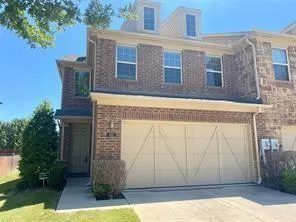 a brick building with a door and a yard
