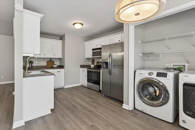 a kitchen with a refrigerator sink and cabinets