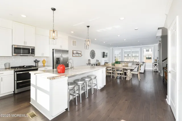 a kitchen with a dining table chairs stove and cabinets