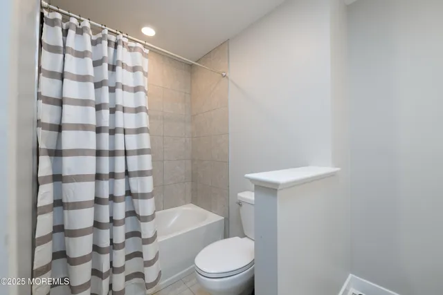 a white toilet sitting next to a shower curtain