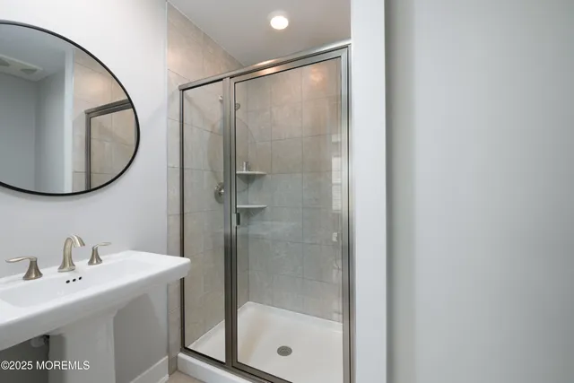 a bathroom with a sink mirror and shower