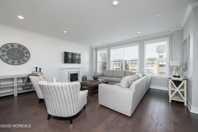 a living room with furniture a large window and a wooden floor