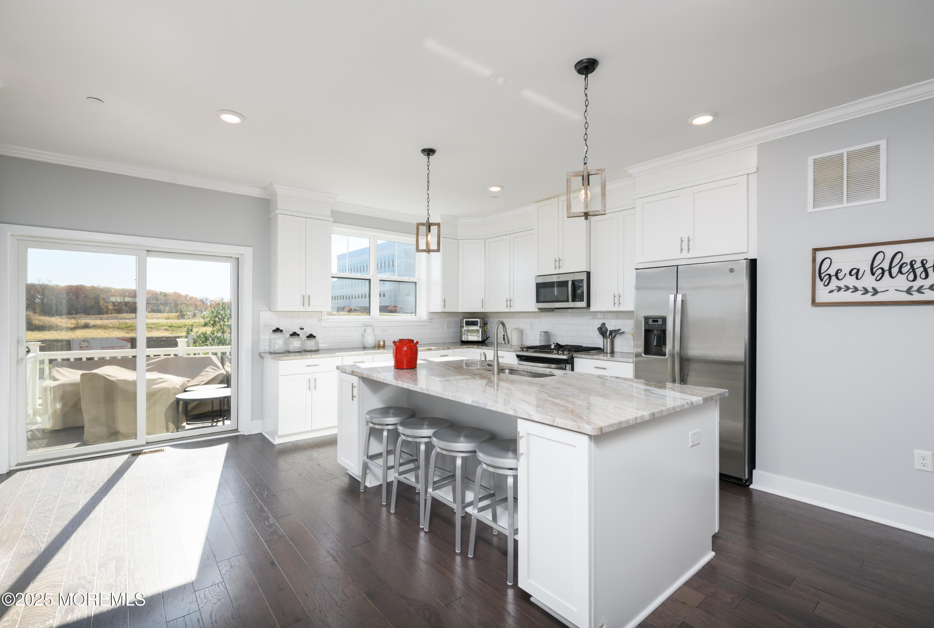 26 Kelly Way Tinton Falls, NJ 07724 - Photo 9 of 33 a kitchen with stainless steel appliances granite countertop a stove top oven a refrigerator a sink and a dining table with wooden floor