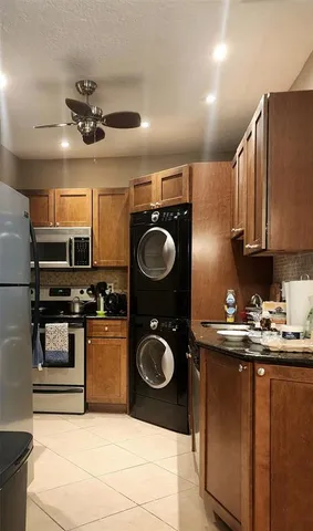 a kitchen with stainless steel appliances granite countertop a sink a stove top oven and refrigerator