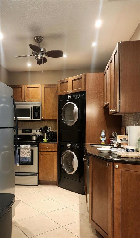 2270 Northeast 68th Street, Unit 1903 Fort Lauderdale, FL 33308 - Photo 5 of 7 a kitchen with stainless steel appliances granite countertop a sink a stove top oven and refrigerator