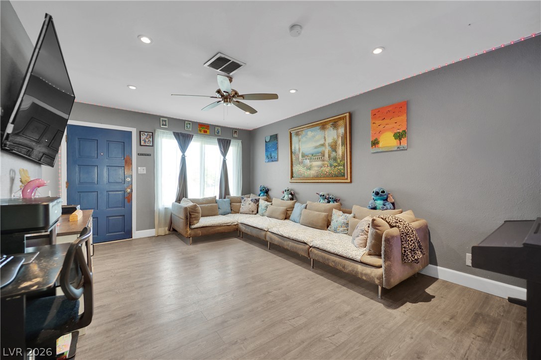 2221 Englestad Street North Las Vegas, NV 89030 - Photo 5 of 32 A comfortable living space boasts a ceiling fan, recessed lighting, and durable hardwood flooring.