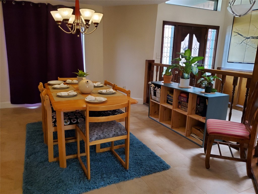 14834 La Rana Drive Houston, TX 77083 - Photo 11 of 14 Cozy dining area for six with chandelier, blue rug, and stained glass entry.