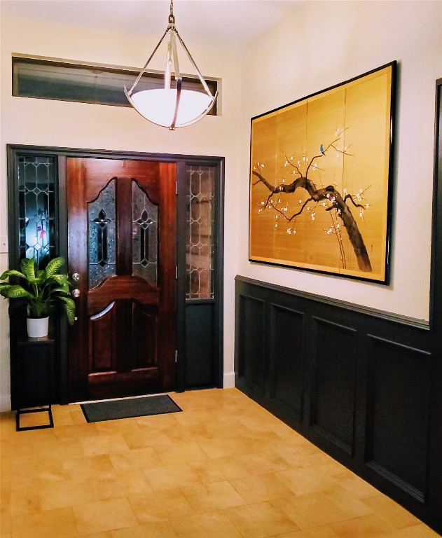 14834 La Rana Drive Houston, TX 77083 - Photo 13 of 14 Inviting entryway with wooden door, decorative glass, wainscoting, and stylish lighting.