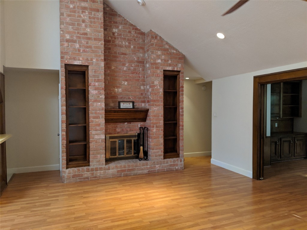 14834 La Rana Drive Houston, TX 77083 - Photo 7 of 14 Cozy living room with brick fireplace, built-ins, vaulted ceilings, and wood floors.