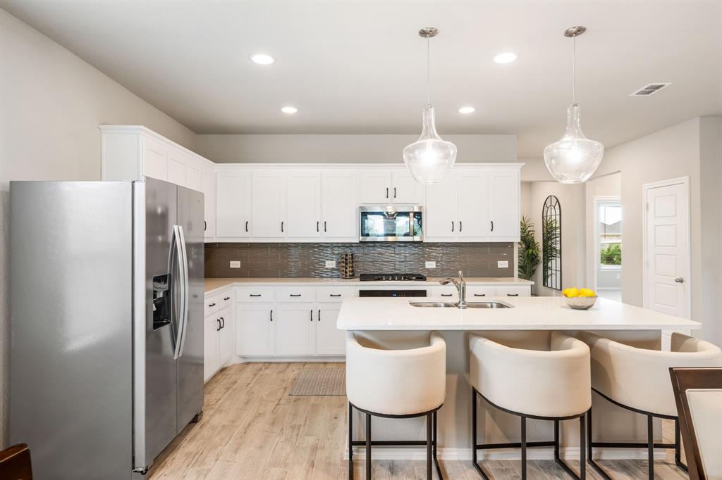 321 Pasture Drive Midlothian, TX 76065 - Photo 12 of 40 a kitchen with stainless steel appliances kitchen island granite countertop a dining table and chairs