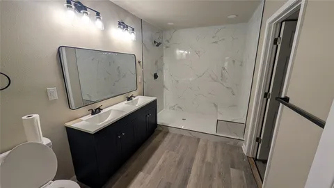 a bathroom with a double vanity sink toilet and mirror