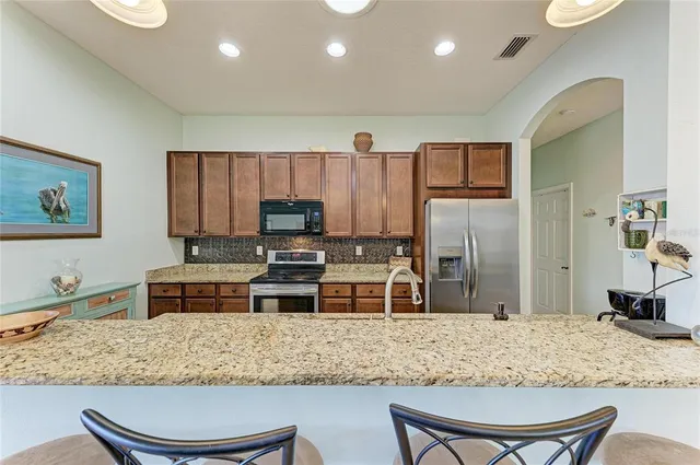 a kitchen with granite countertop a sink stove and cabinets