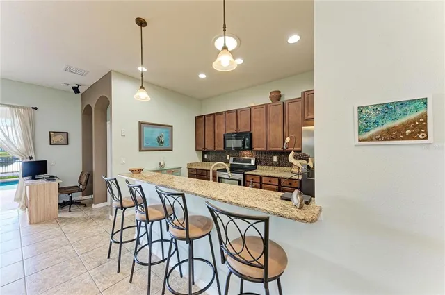 a large kitchen with kitchen island a large counter space a sink stainless steel appliances and cabinets