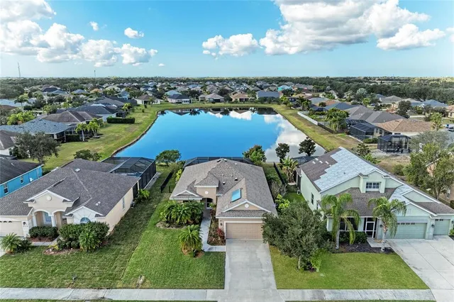 an aerial view of a house with a yard and lake view