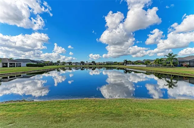 an aerial view of a house with swimming pool a yard and lake view