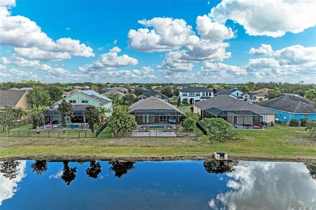 a view of a park that has a sign board large trees