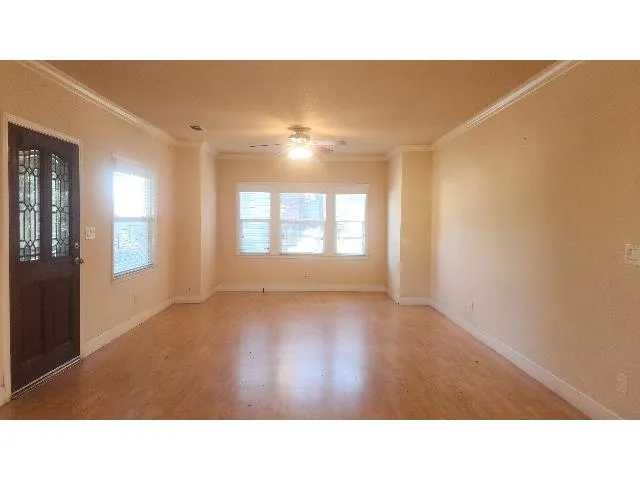 a open hall with a floor to ceiling window and wooden floor