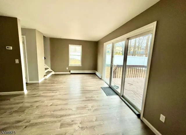 an empty room with wooden floor and entrance