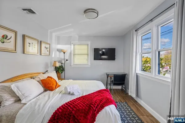 a bedroom with two bed and a potted plant